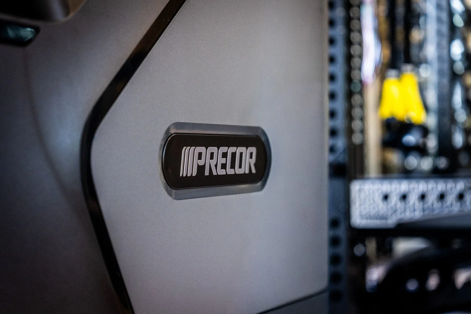 Close-up of Precor cardio equipment branding in modern custom home gym setting