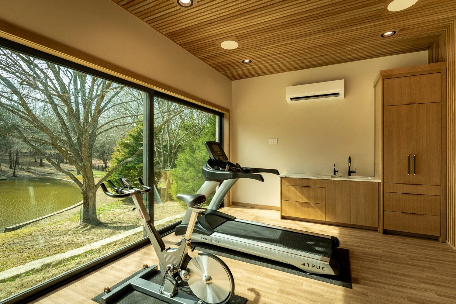 Custom home gym with power rack, adjustable bench, weight plates, and premium strength training equipment with wood panel design