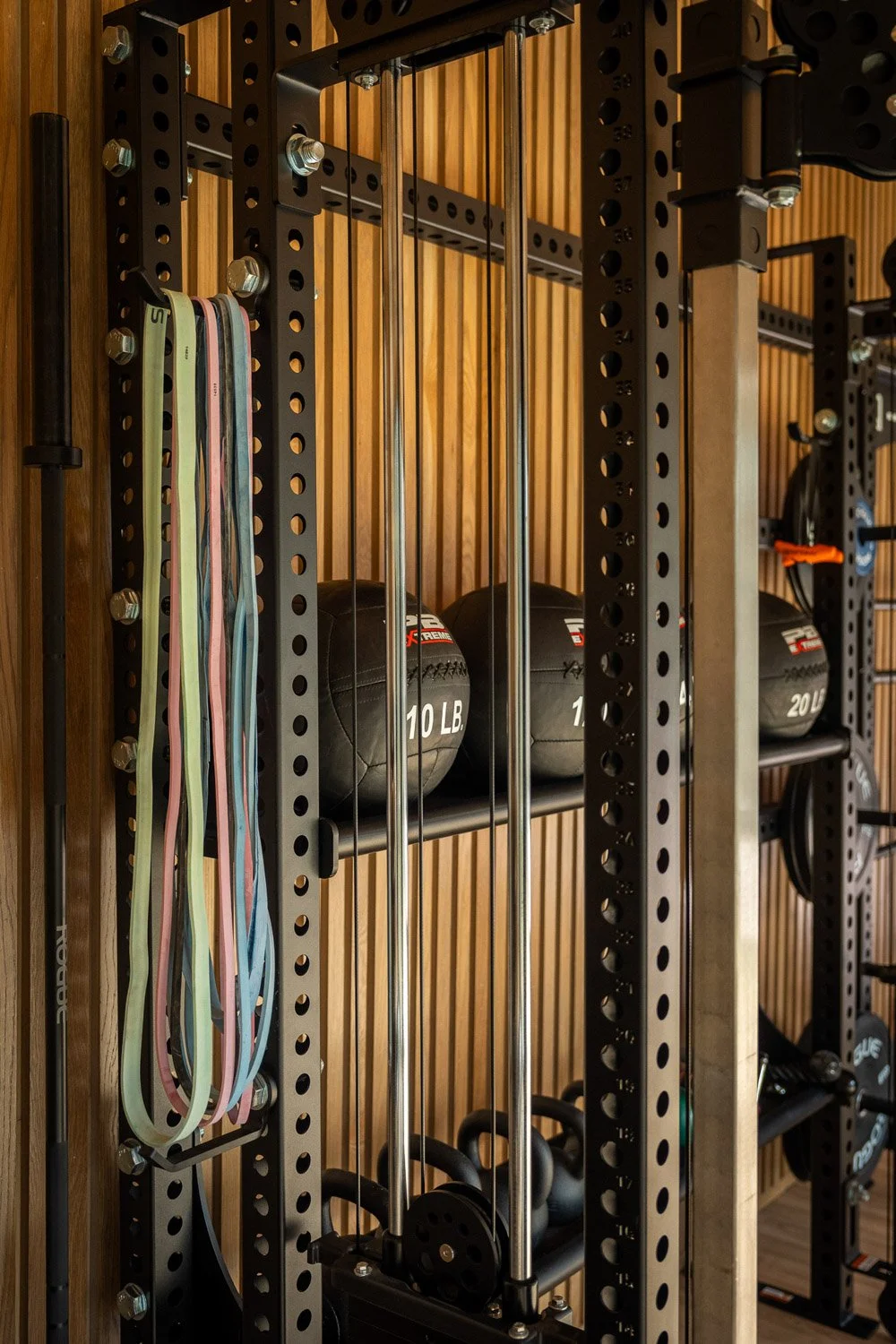 Custom home gym equipment rack with resistance bands, cable system, and organized strength training accessories