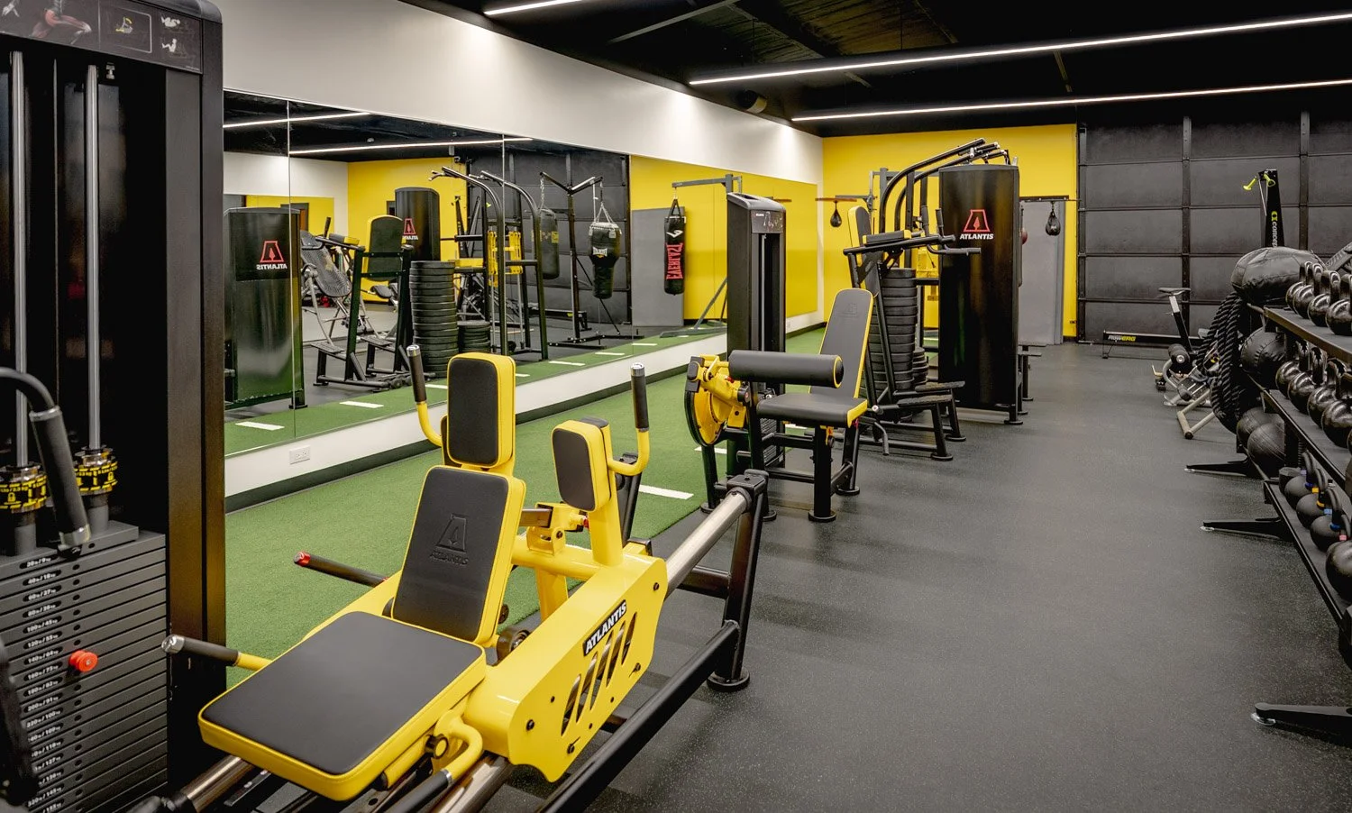 Luxury custom home gym design featuring Atlantis strength equipment, turf training area, and wall mirrors