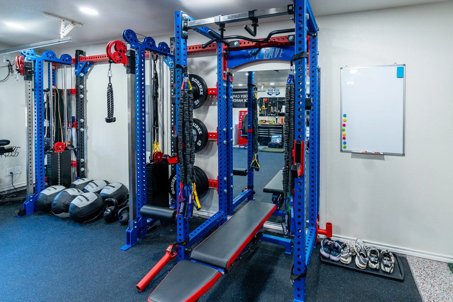 Modern home gym featuring adjustable workout bench, power rack with resistance bands, and full strength training setup