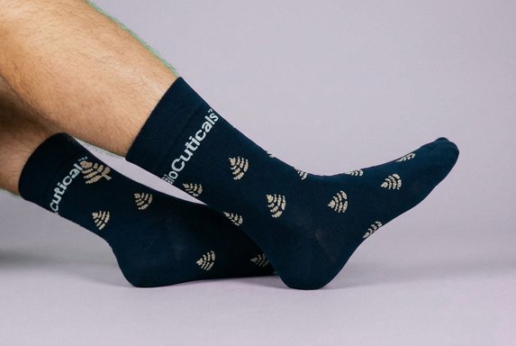 Navy dress socks with custom design of Bioceucitrals leaf icon repeated over sock and their brand name at the top