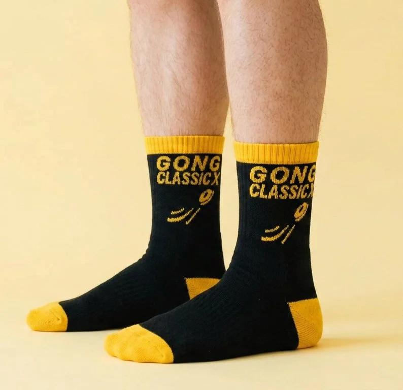 Person wearing black sports quarter socks with yellow branding on them