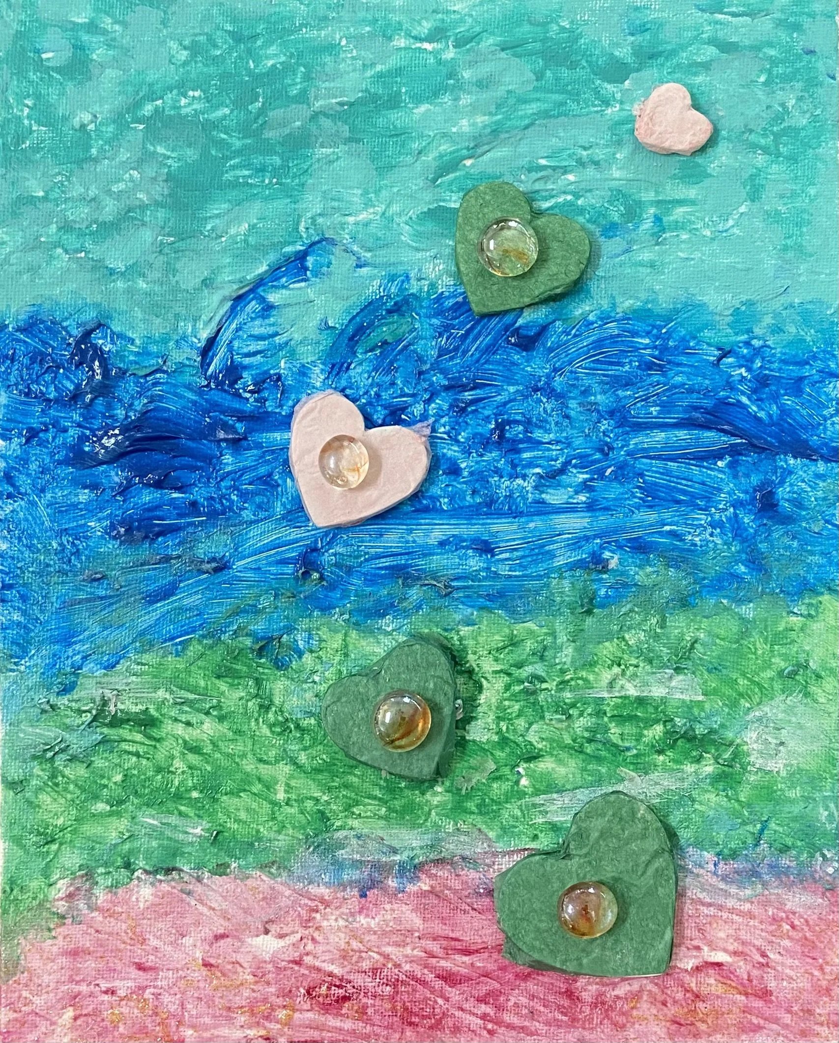 Art piece by Natalie Warren, with pink marbles in center of hearts, across canvas with shades of blue in the background.