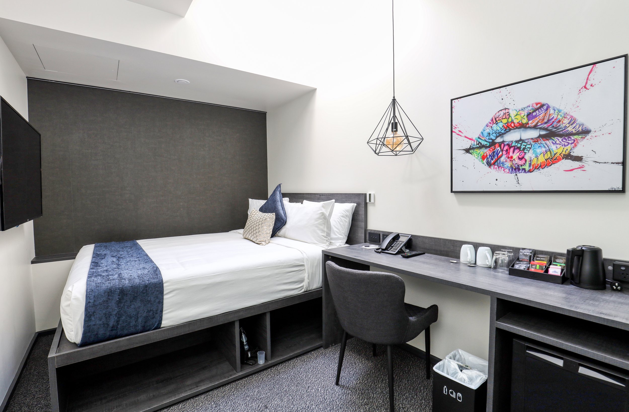 Modern Queen Room at The Viv Hotel in Wellington with comfortable bed, workspace and contemporary artwork.
