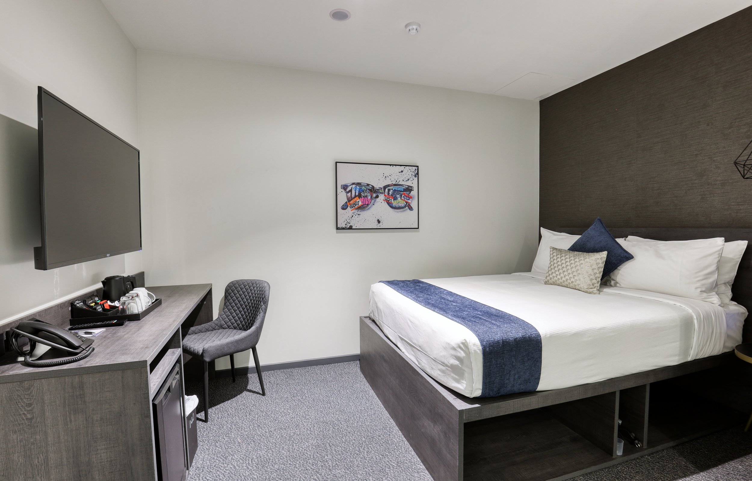 Internal Queen room at The Viv Hotel in Wellington featuring a queen bed, workspace, smart TV and contemporary décor.