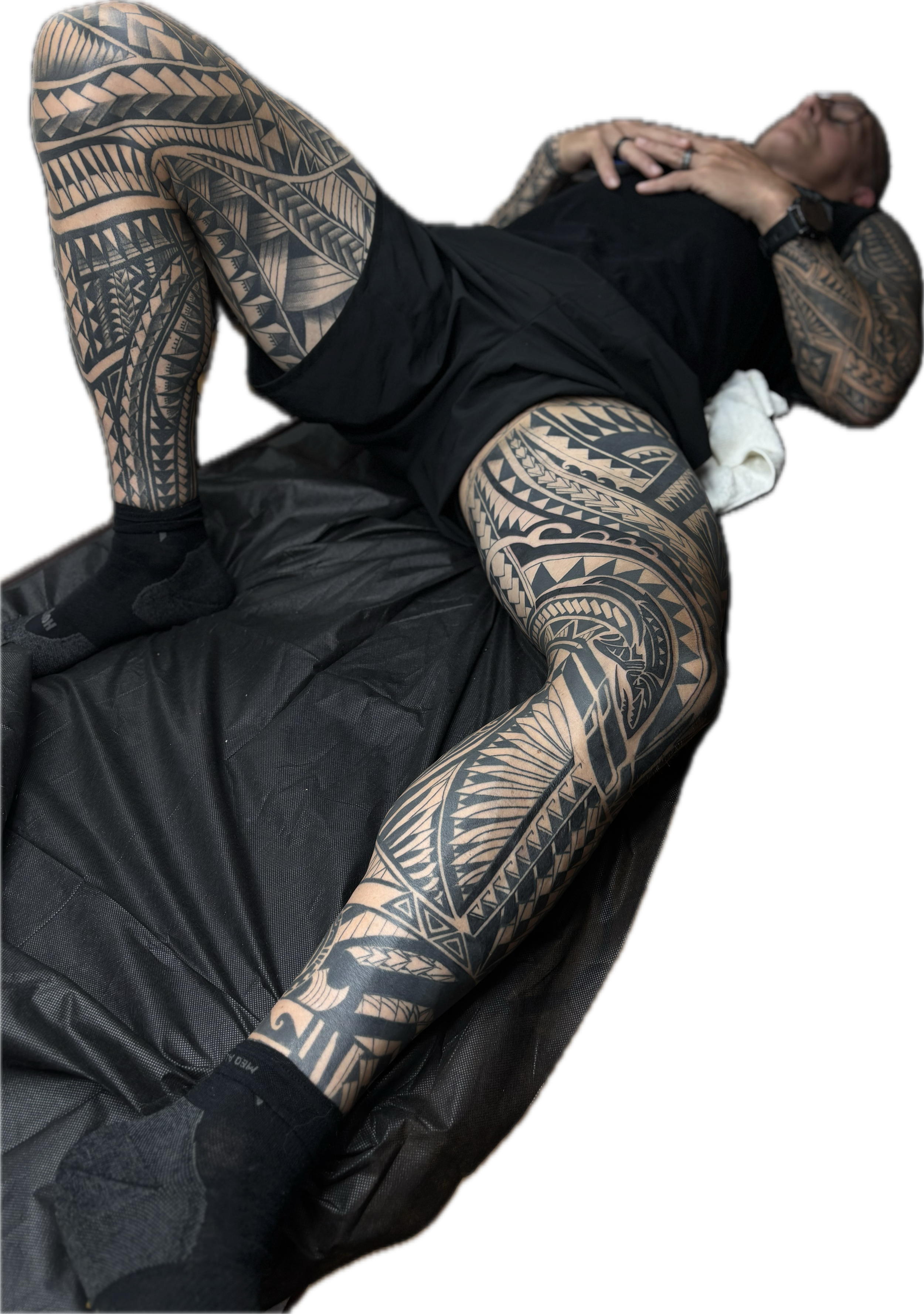 A man with extensive geometric tribal tattoos. his body suit tattoo is almost complete