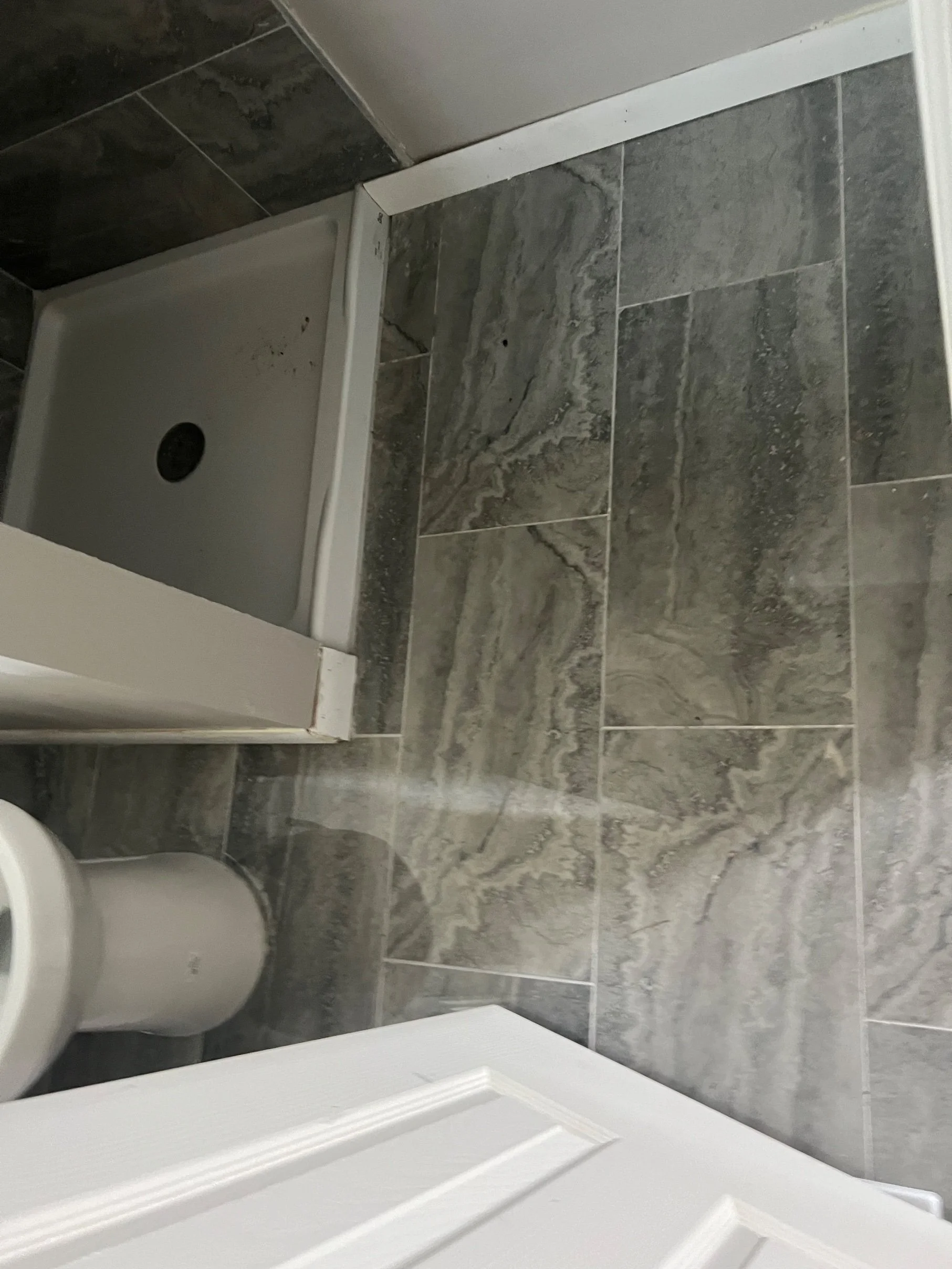 In progress — shower pan and first tile