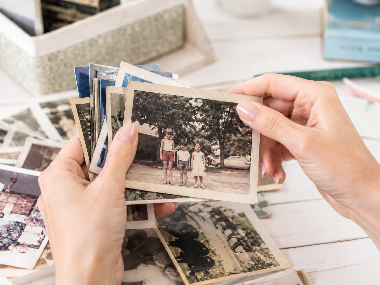 Hand holding old print photos and sorting and organizing the photos. | Cheryl DiFrank | My Memory File