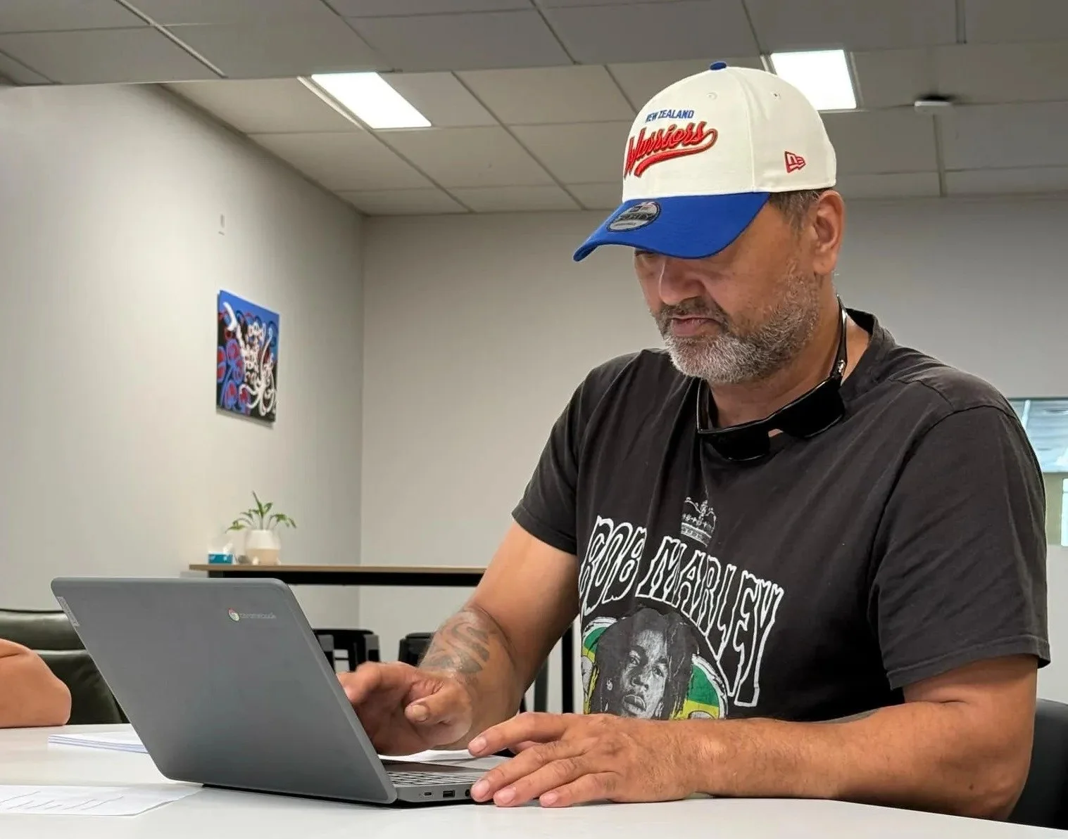 A person sits at a table using a laptop during a Katoa Connect learning session. The image reflects digital skills training, focus, and everyday learning support.