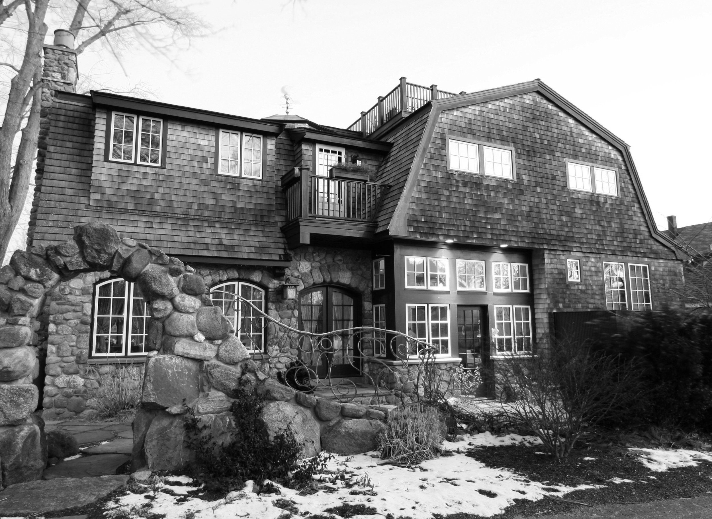 Custom home design in Cape Cod, MA, by Burke Architecture & Design Associates featuring shingle and stone siding, large windows, with a lovely balcony and garden.