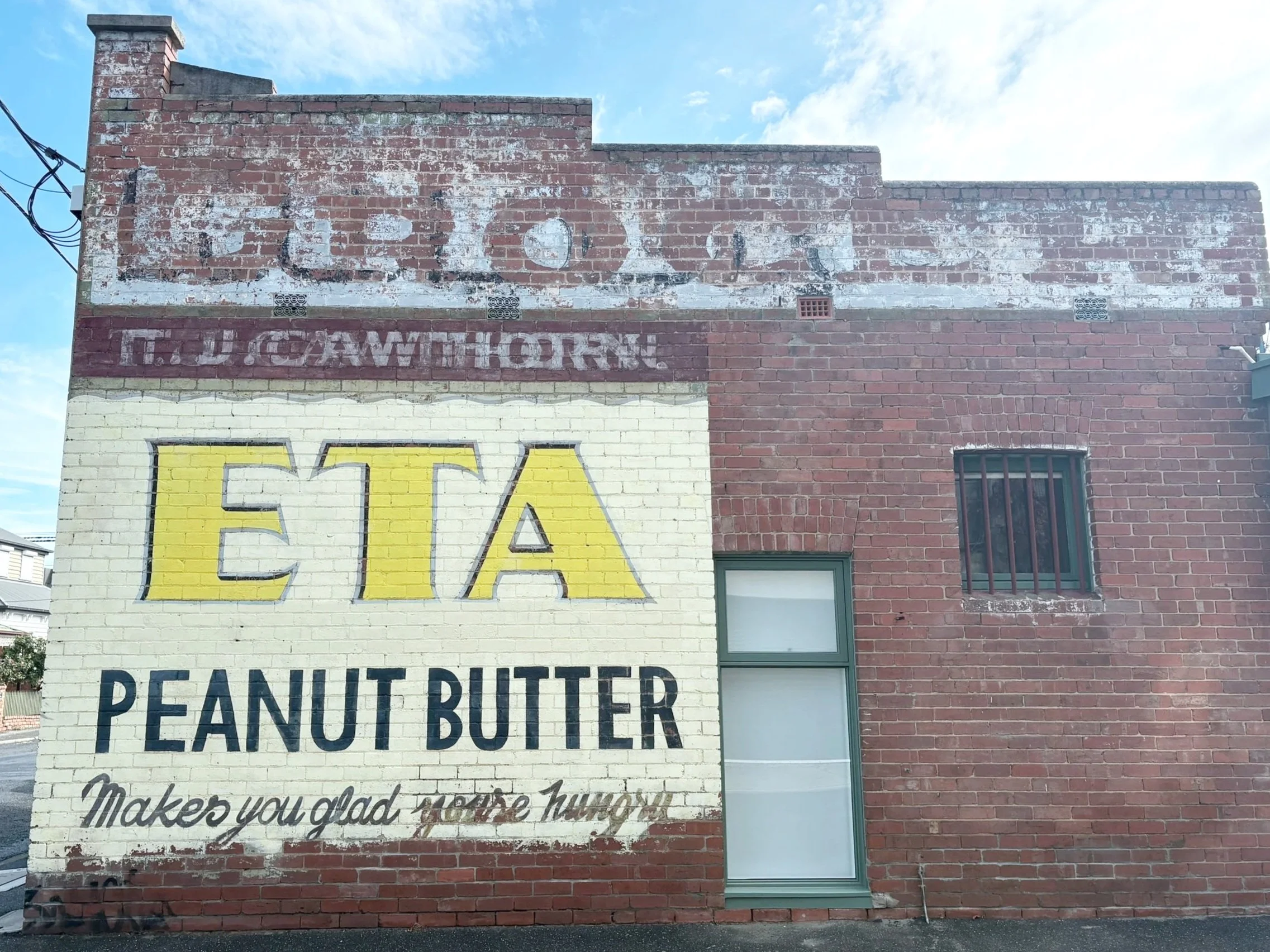 Iconic red brick building with ghost signage located in Seddon, Melbourne. ETA Peanut Butter.