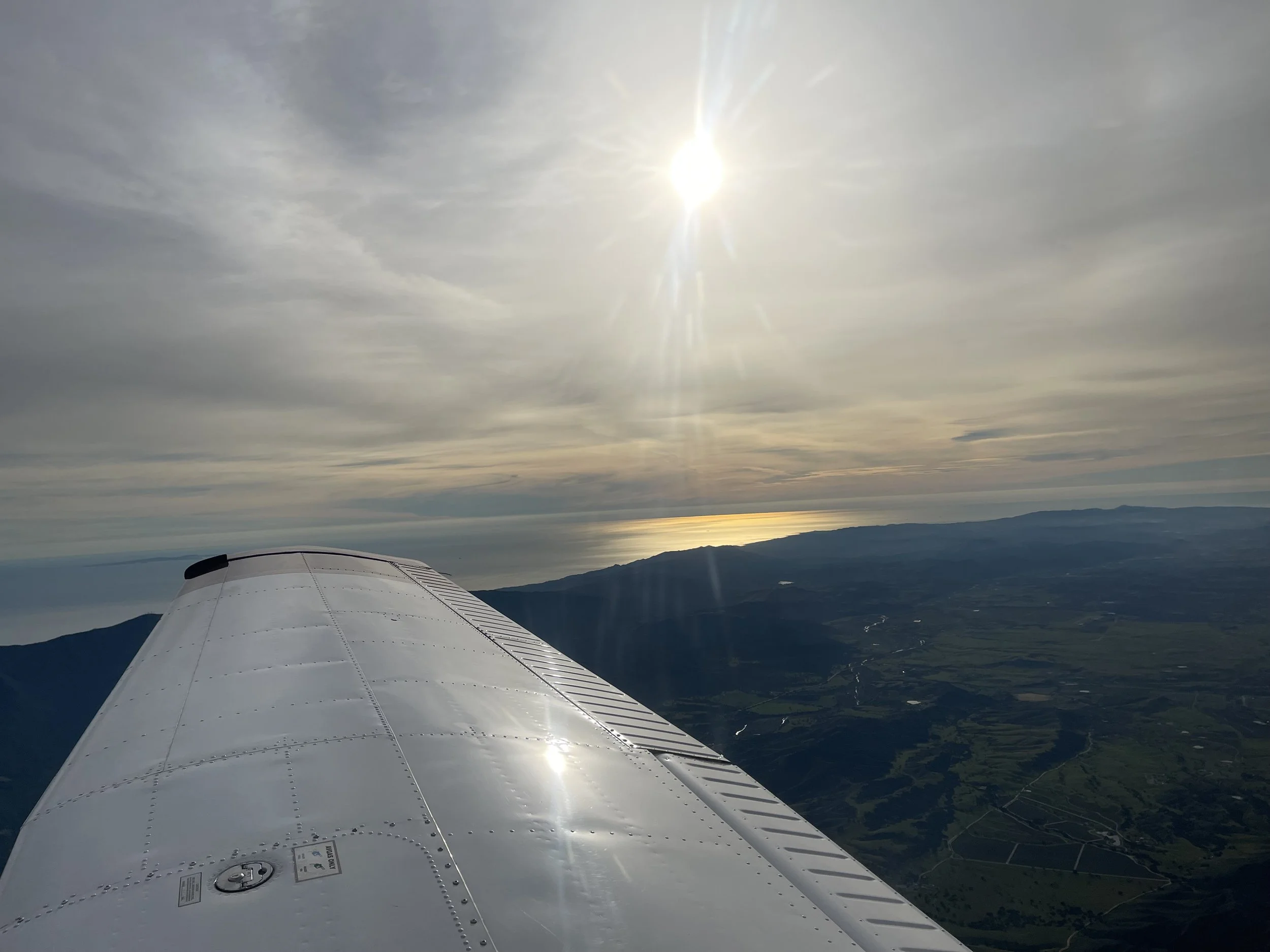 Sunset viewed through an airplane window above the clouds