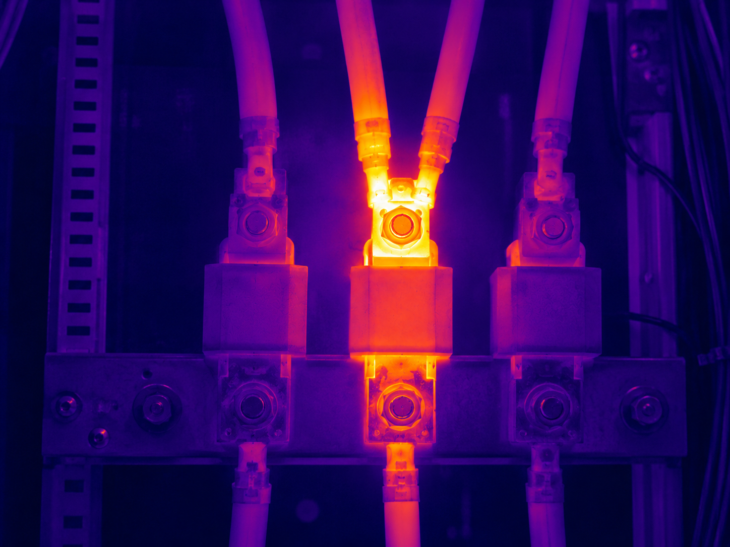 Electrician using a thermal imaging camera to inspect a switchboard