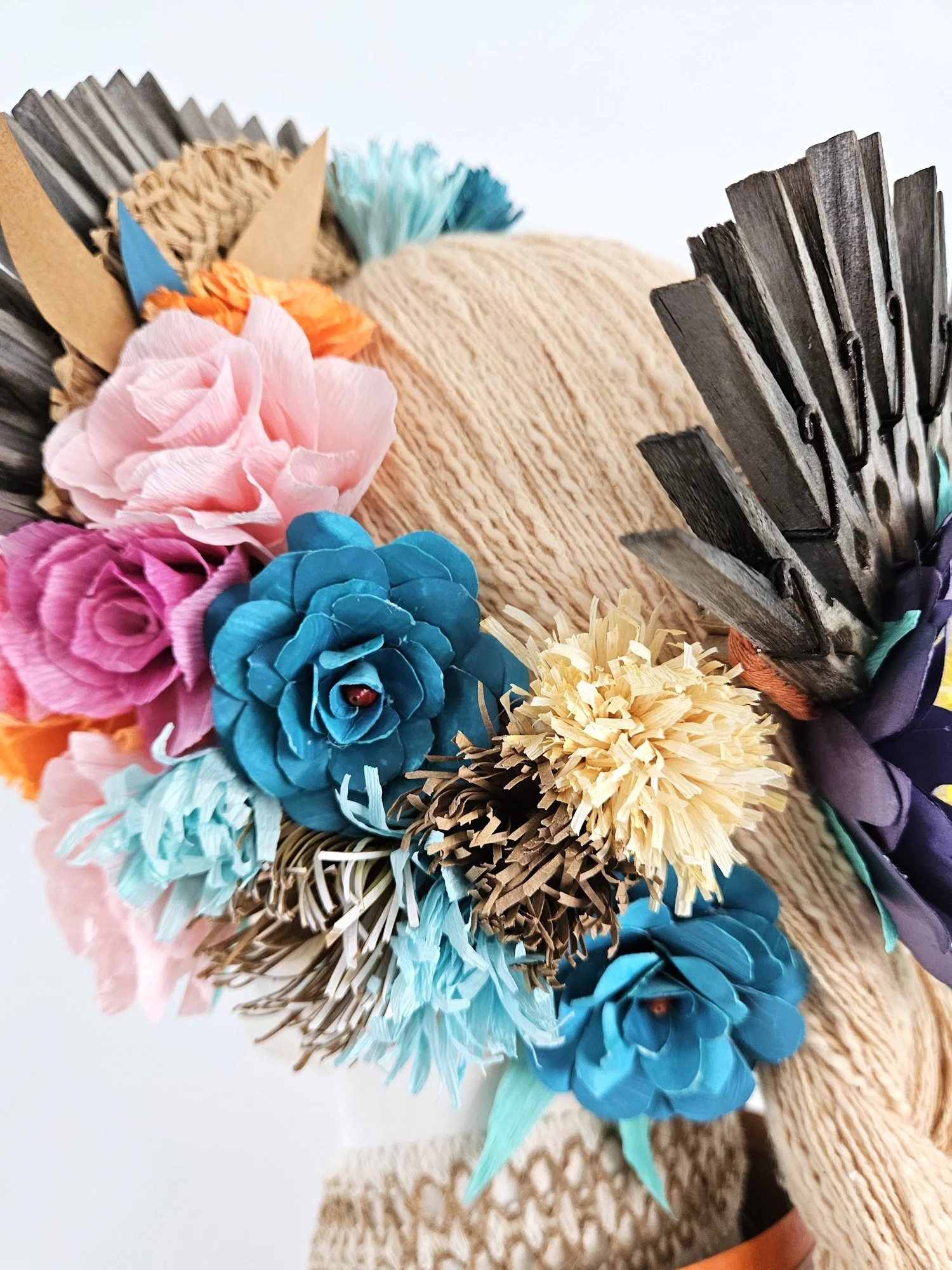 Close-up of a colourful headpiece made of paper flowers.