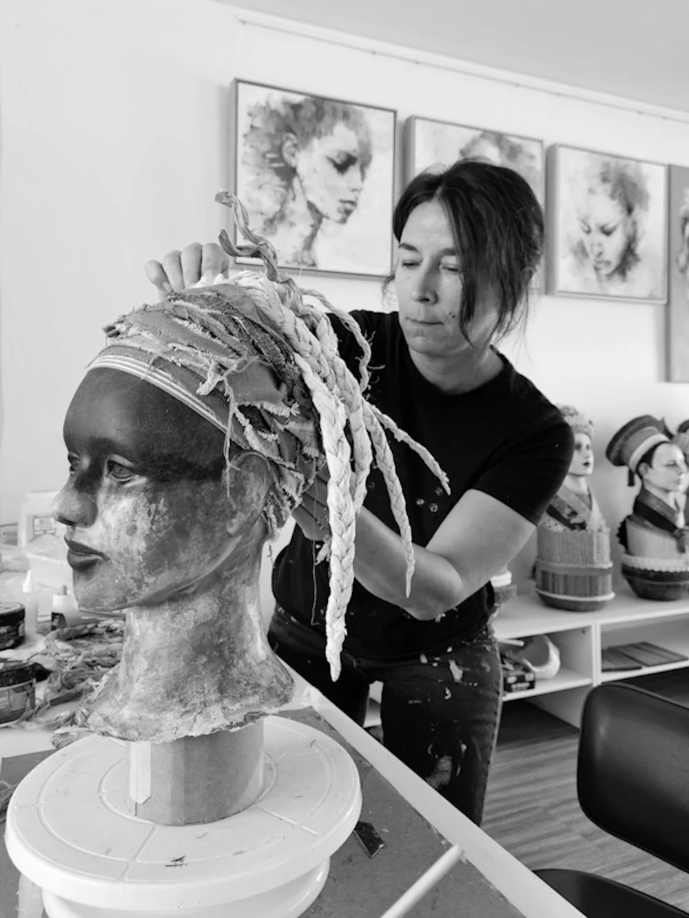 Artist working on a sculpted bust in an art studio
