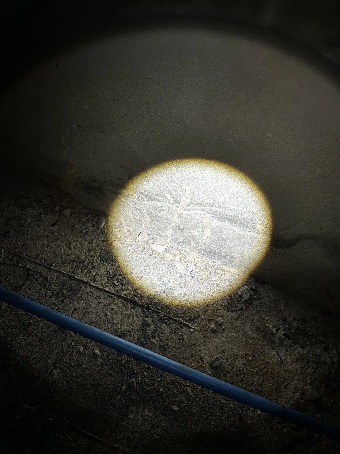 A light beam on a concrete wall and floor at a construction site.