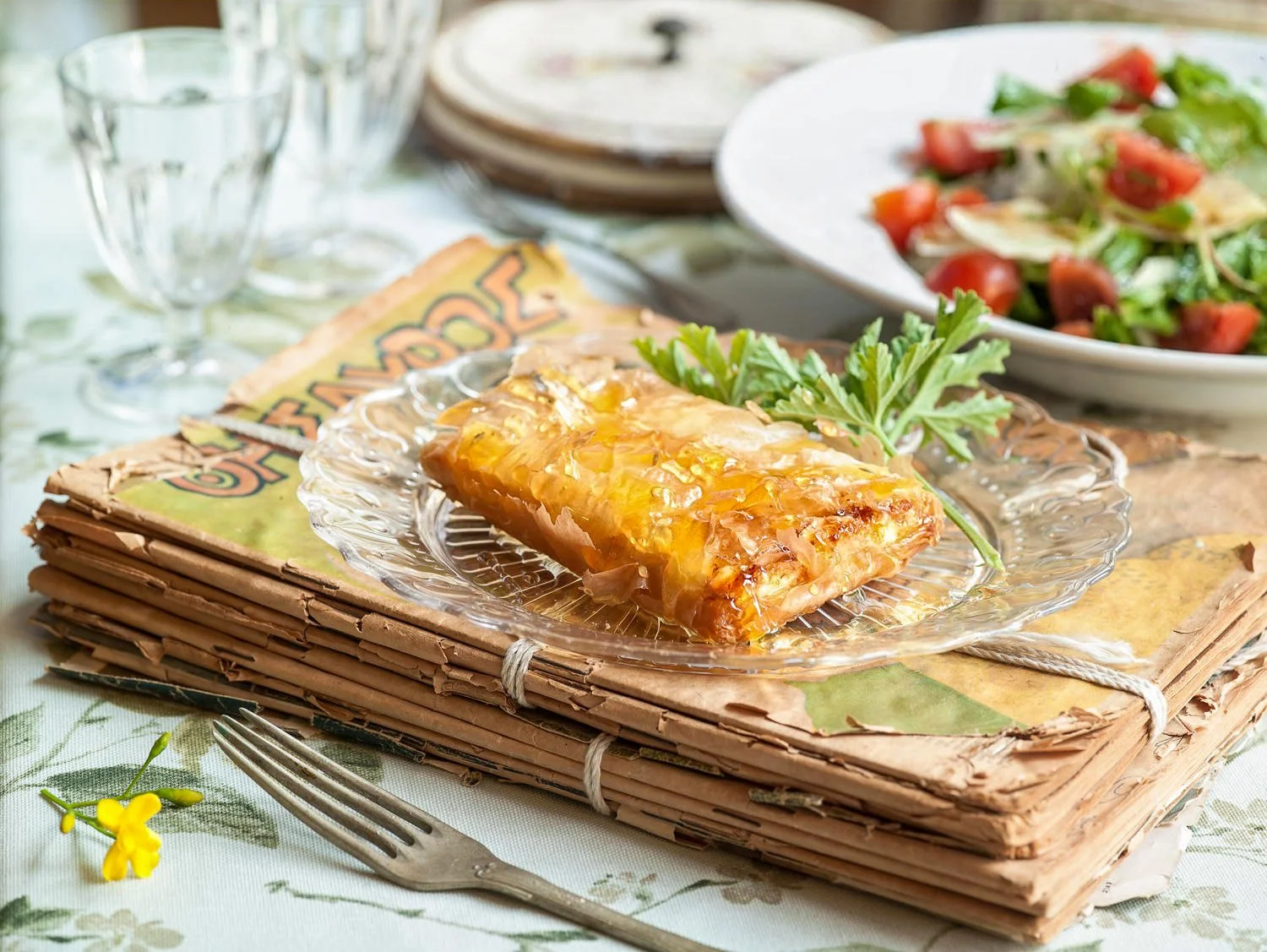 Traditional Greek cheese pie with handcrafted phyllo pastry drizzled with honey, served on a rustic vintage book setting. Photography & styling  Stavros Kostakis