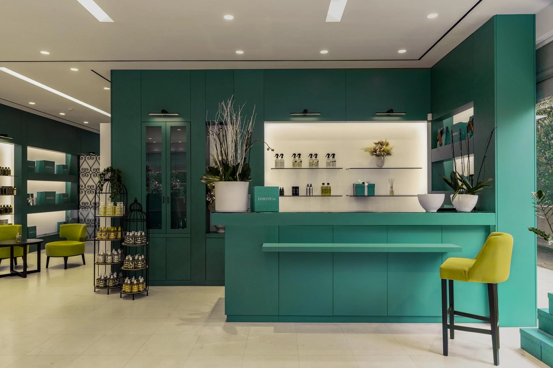 Minimalist teal reception counter and bar area with professional architectural lighting by Stavros Kostakis Photography.