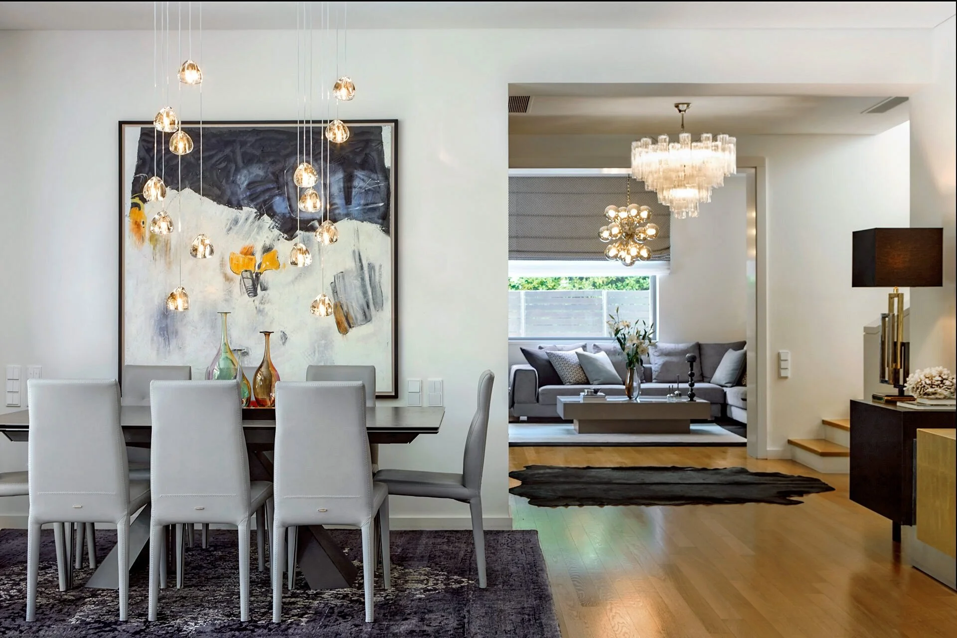 interior photography of a luxury dining room in Ekali by Stavros Kostakis. Features Sissy Feida custom crystal chandeliers, bubble-glass pendant lighting, and designer dining furniture.
