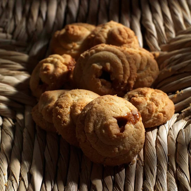Handmade traditional cookies on woven basket, artisan gastronomy photography by Stavros Kostakis