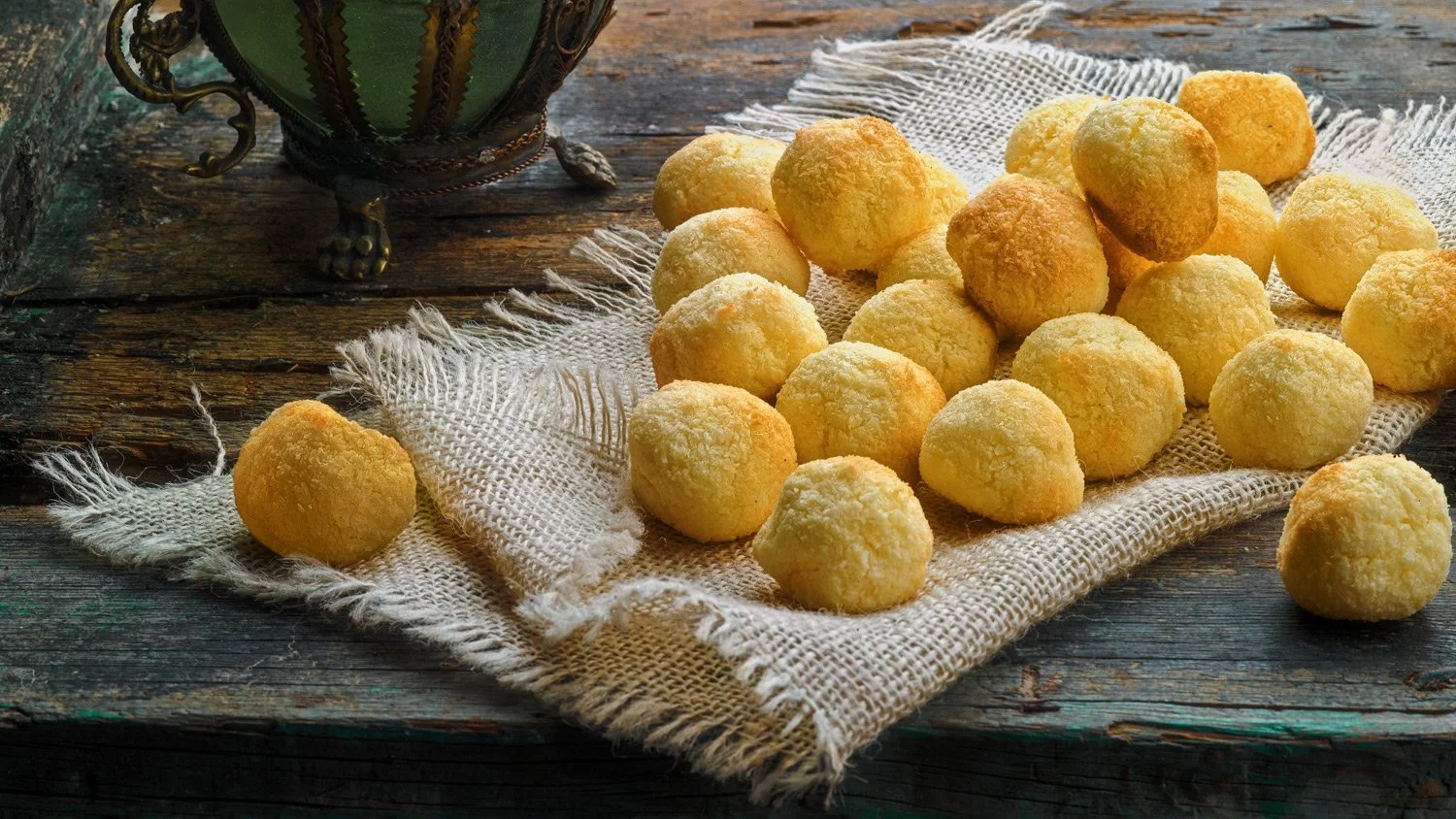 Professional food styling & food photography for Argiro Barbarigou, featuring traditional coconut macaroons (karydes) on a rustic burlap cloth, styled with vintage kitchenware for a warm, artisan feel.