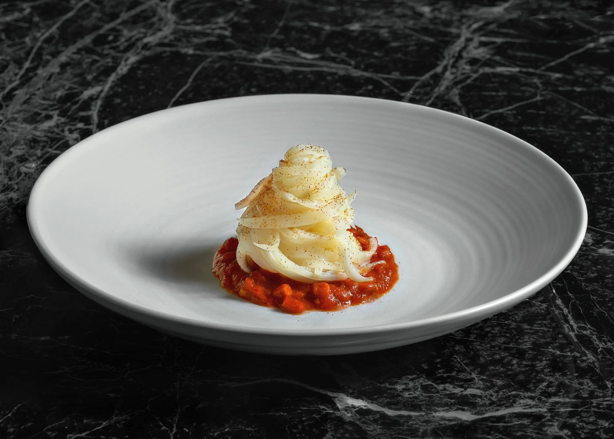 A signature fine dining dish by Chef Giannis Liokas. Minimalist culinary photography on black marble, featuring vibrant textures and elegant plating. Captured at Monzu, Athens, by Stavros Kostakis.