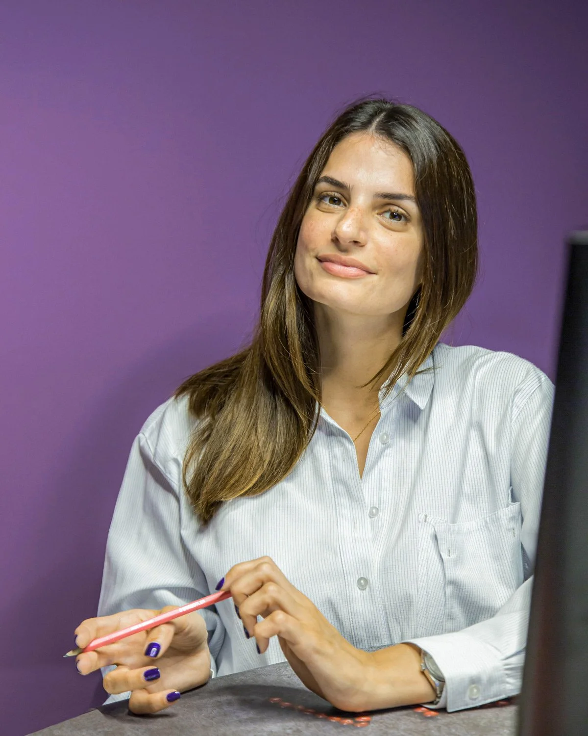 Vibrant color corporate portrait of Marita Simoneti (Aria Fine Catering) against a bold purple background. This professional headshot by Stavros Kostakis captures an approachable and confident executive presence, ideal for modern business branding