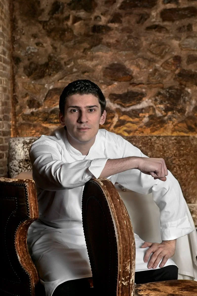 Elegant professional portrait of 2-star Michelin Chef Arnaud Bignon in a refined, classic setting. A high-end gastronomy character study by Stavros Kostakis that emphasizes culinary excellence, authority, and sophisticated branding for luxury hospita