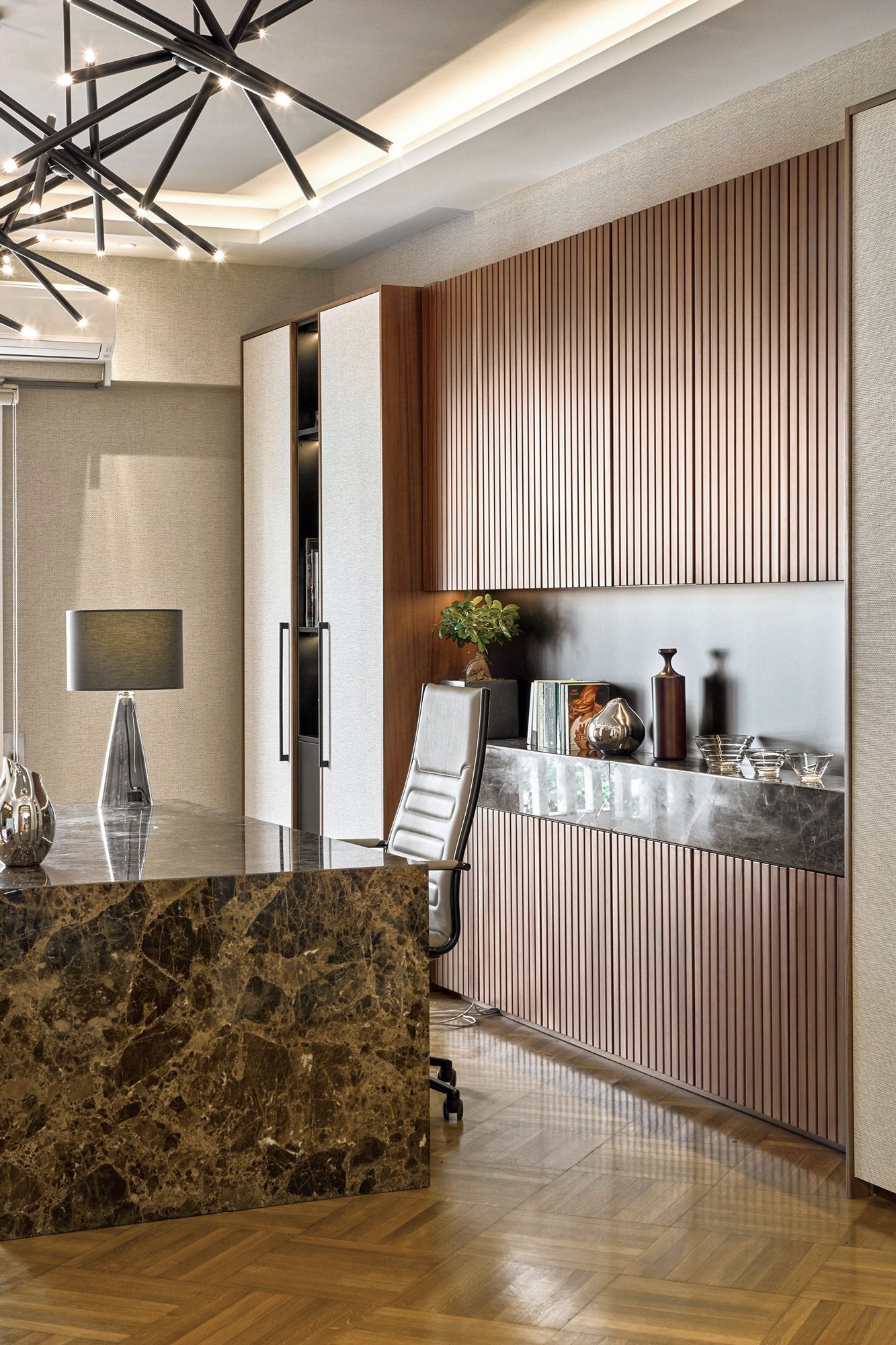 Interior detail photography of a luxury law firm in Kolonaki, designed by Sissy Feida. The shot highlights the custom wood paneling, dark marble surfaces, and integrated LED lighting, along with curated office styling. Photographed by Stavros Kostaki