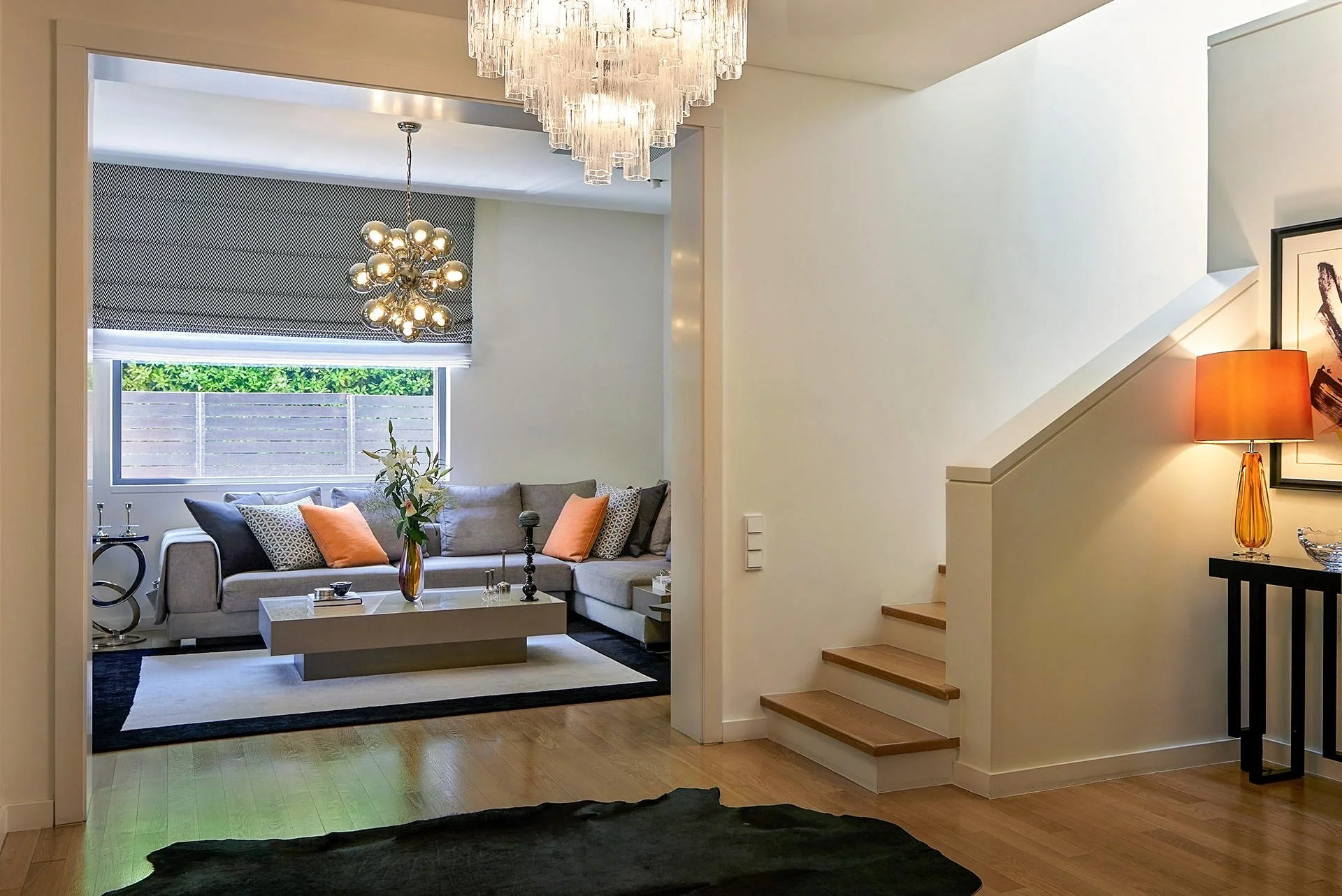Modern villa interior in Ekali designed by Sissy Feida. View of wooden staircase, luxury living room with custom cushions and signature lighting. Photographed by Stavros Kostakis.