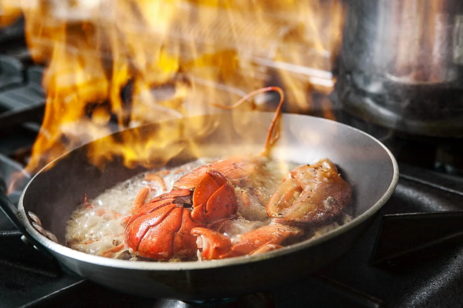 Lobster flambé action shot at Medittera restaurant in Mechelen, Belgium. Cinematic culinary photography by Stavros Kostakis.