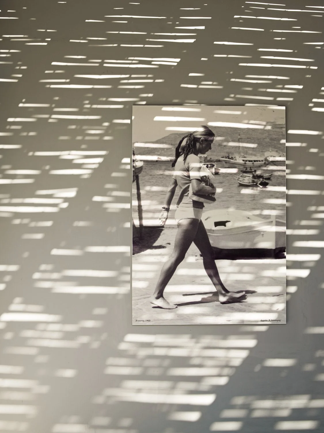 Creative hospitality branding at Bianco Beach House Tinos: A black and white framed photograph of a summer scene integrated with natural shadows...