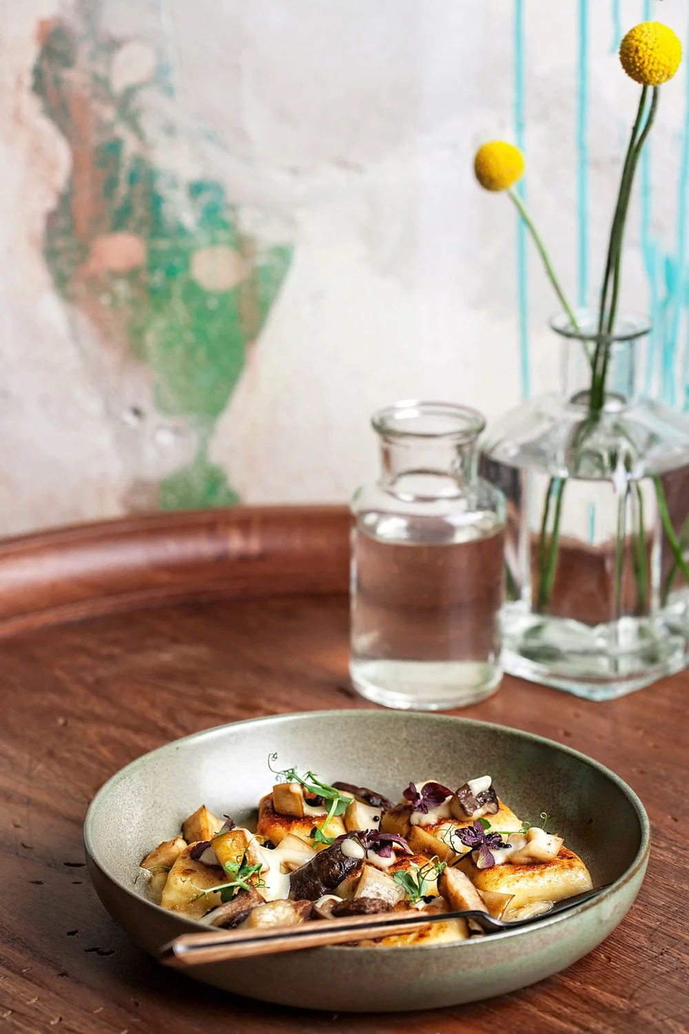 Gourmet gnocchi dish with mushrooms at Jack Rabbit Utrecht, styled with yellow craspedia flowers and rustic textures, photographed by Stavros Kostakis.
