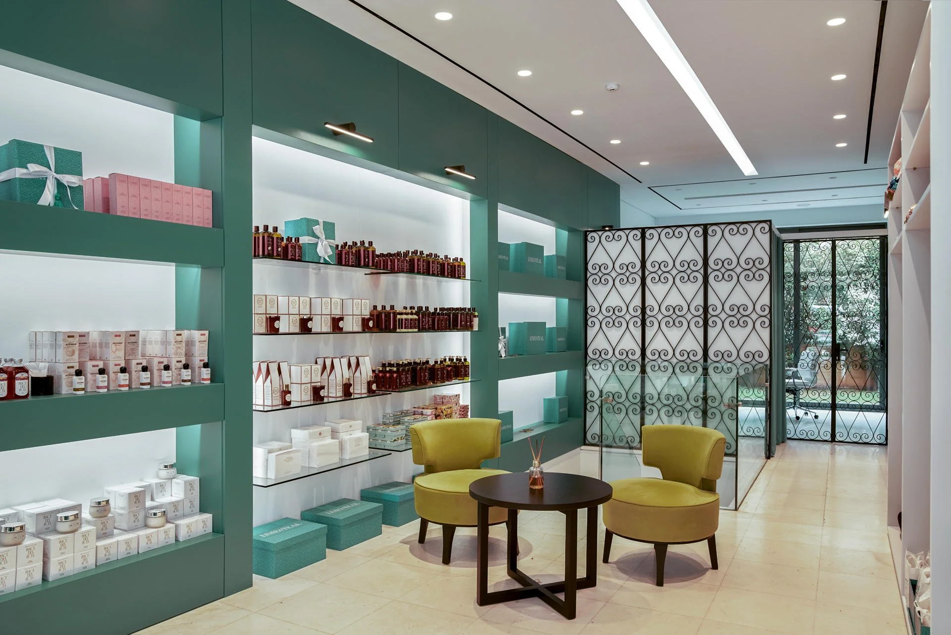 Bespoke product niches and seating area featuring lime armchairs, photographed by Stavros Kostakis Photography.