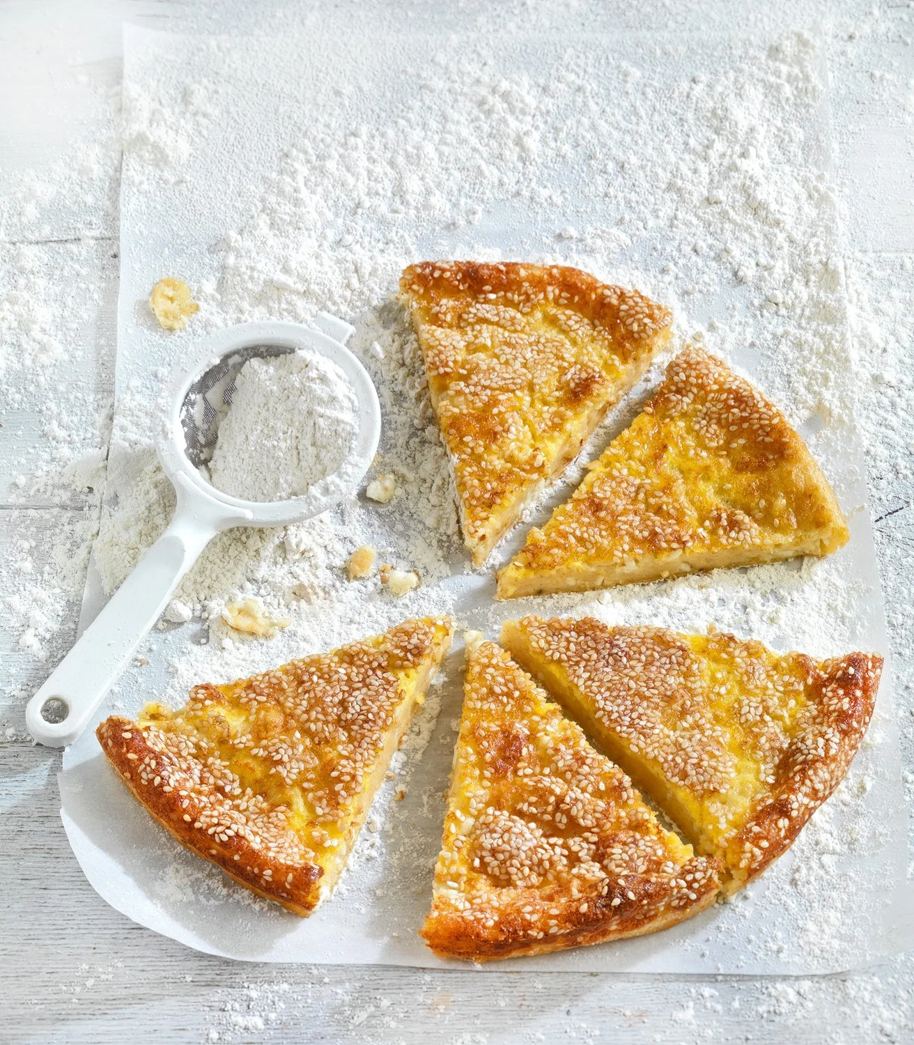 Traditional Greek Zagoritiki Aleuropita (flour pie) with feta cheese and sesame seeds, editorial food photography for Argiro Barbarigou and Alfa Pastry by Stavros Kostakis.