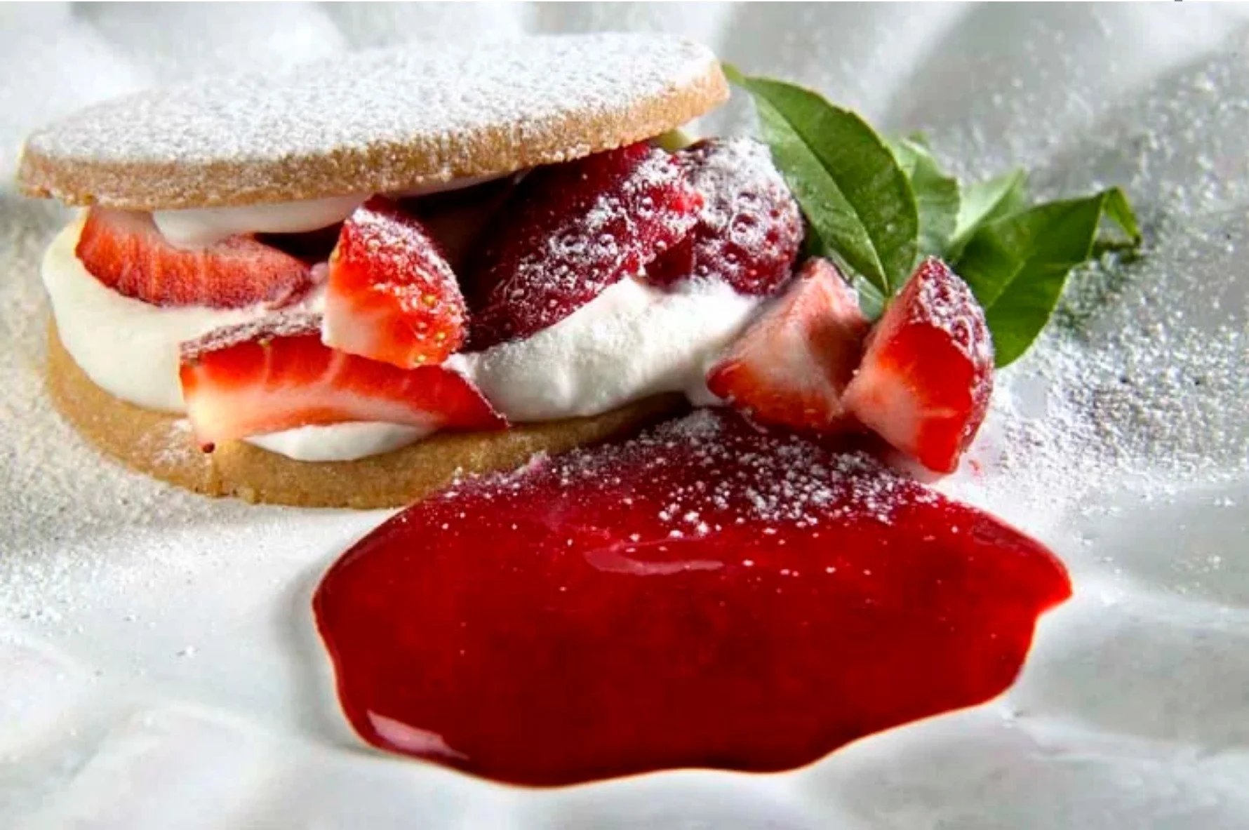 Macro photography of a gourmet strawberry pastry with fresh cream and fruit coulis, capturing rich textures and vibrant colors.