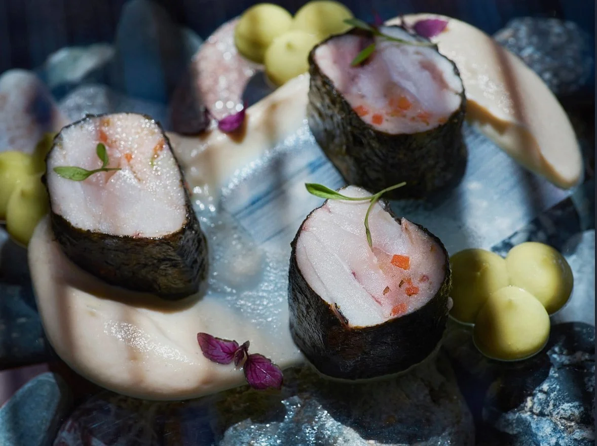 A high-detail gourmet dish at Bianco Beach House in Tinos, featuring seafood rolls with delicate garnishes and creamy textures, photographed by Stavros Kostakis.