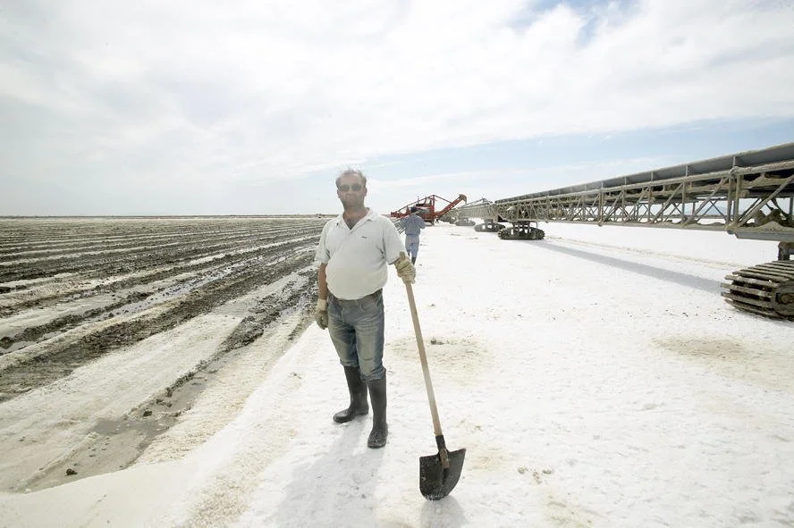 Traditional salt harvesting with shovel, documentary photography of manual labor by Stavros Kostakis Photography.