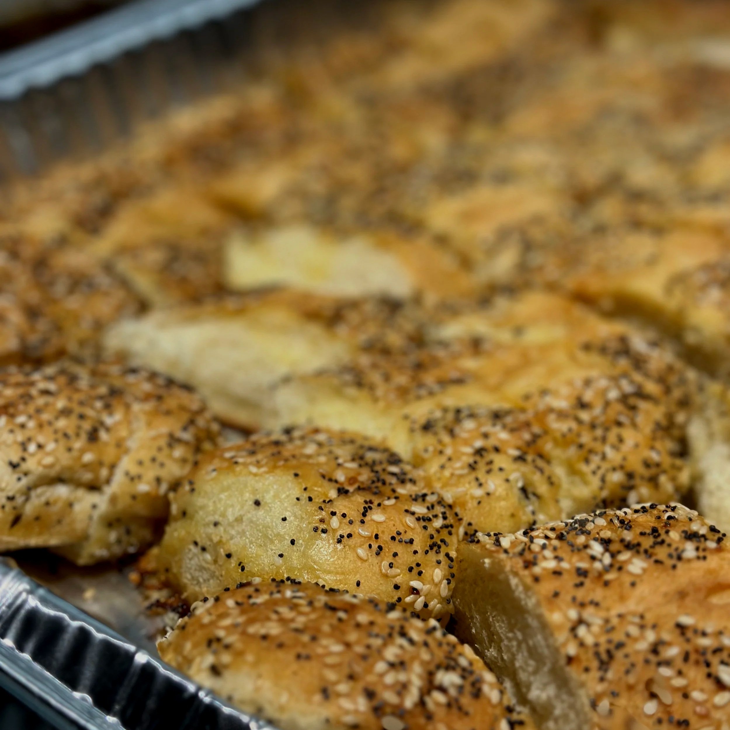 Close-up of sesame and poppy seed bagel with seeds visible on the crust.