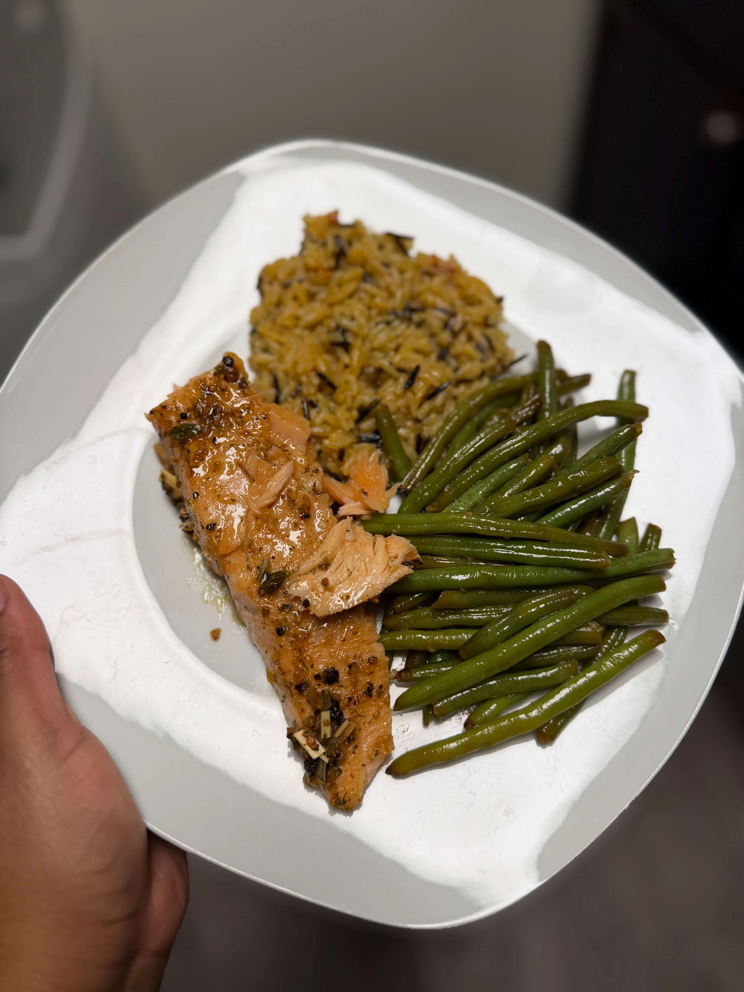 Dinner plate with baked salmon, cooked rice, and green beans.