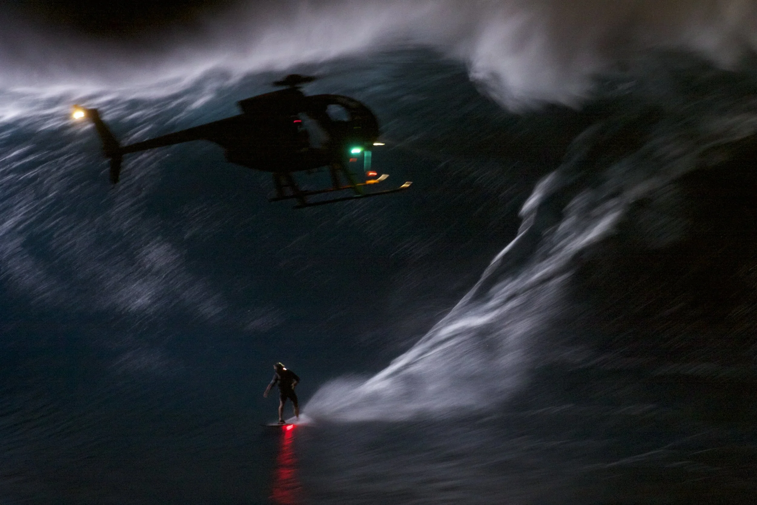 Mark Visser surfing the world-first Night Rider wave at Jaws, Pe'ahi, Maui, in darkness.