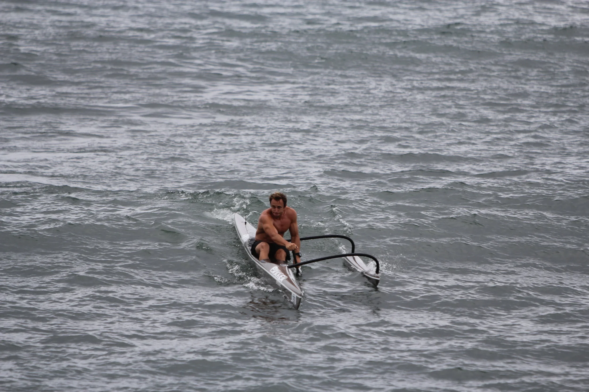 Mark Visser competing in an outrigger canoe at the Ultimate Waterman competition, New Zealand