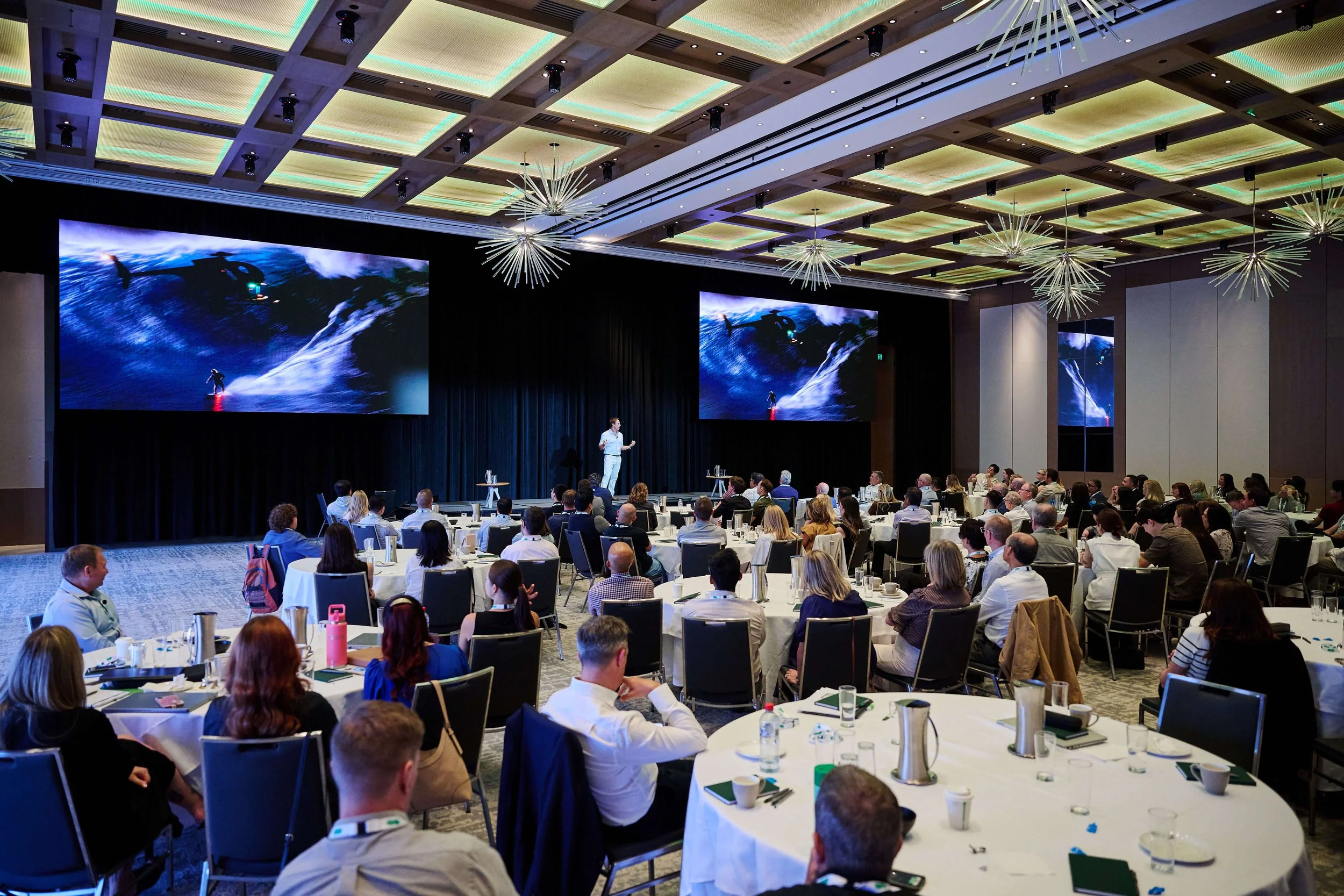 Corporate speaker Mark Visser engaging a large audience during a business workshop conference.