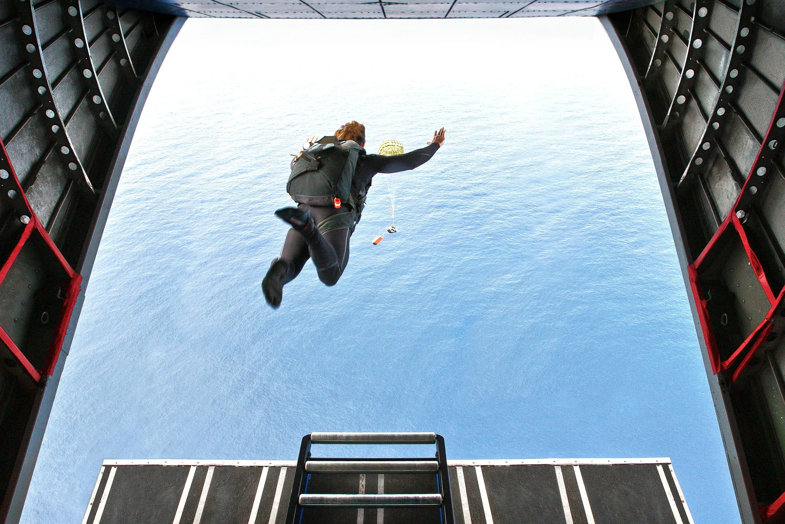 Mark Visser parachuting from an aircraft during the filming of Operation Deeper Blue, an expedition exploring human performance in extreme environments.