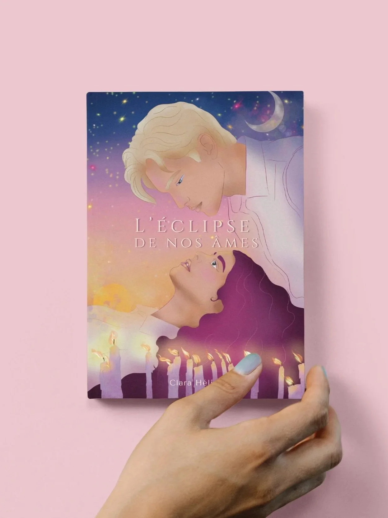 A person holding a French book titled "L'eclise de nos âmes" by Clara Hélène with an illustration of a blonde man and a woman with dark hair looking at each other, set against a starry sky with a crescent moon and candles.