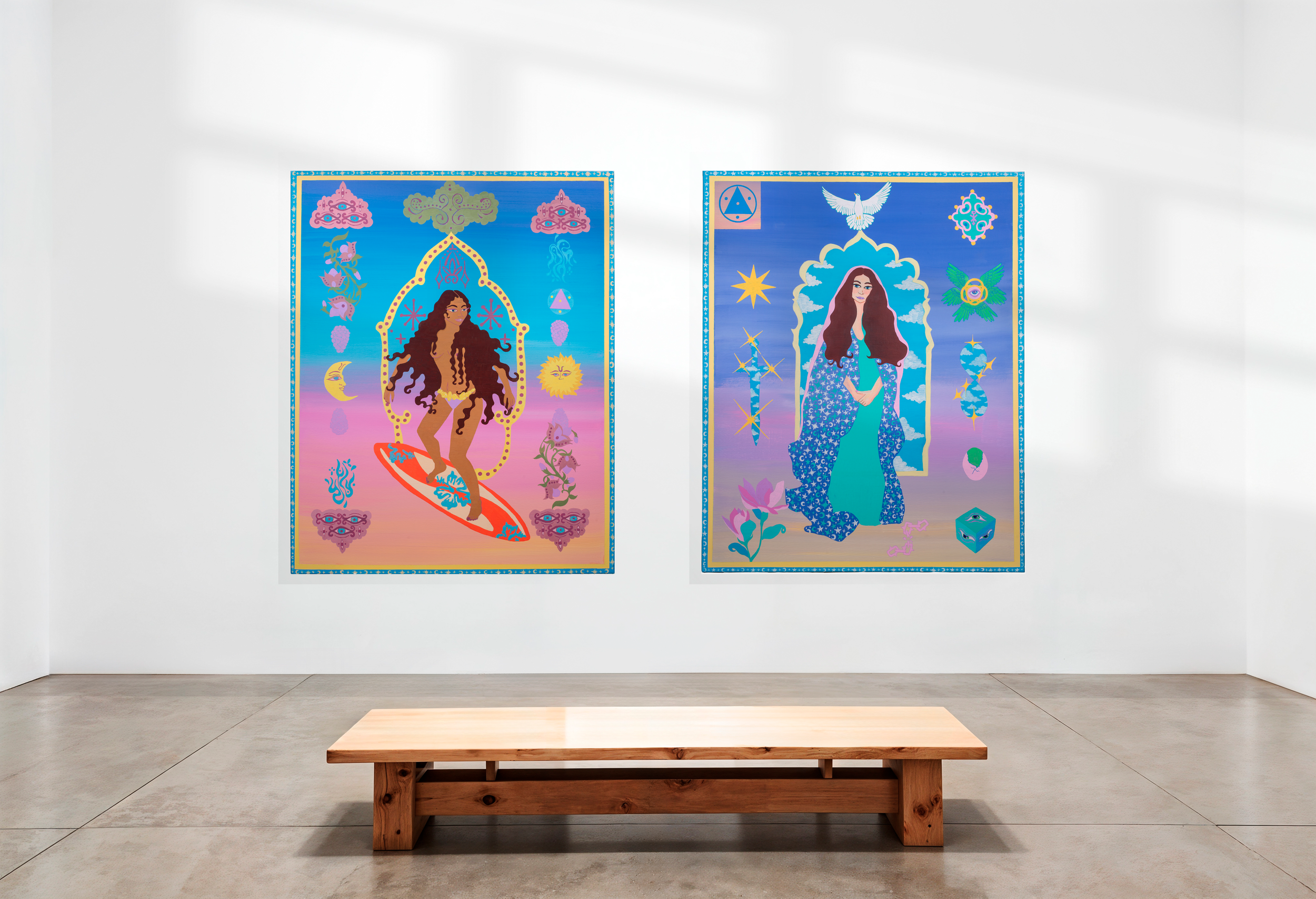 Two colorful, surreal art posters displayed on a white gallery wall