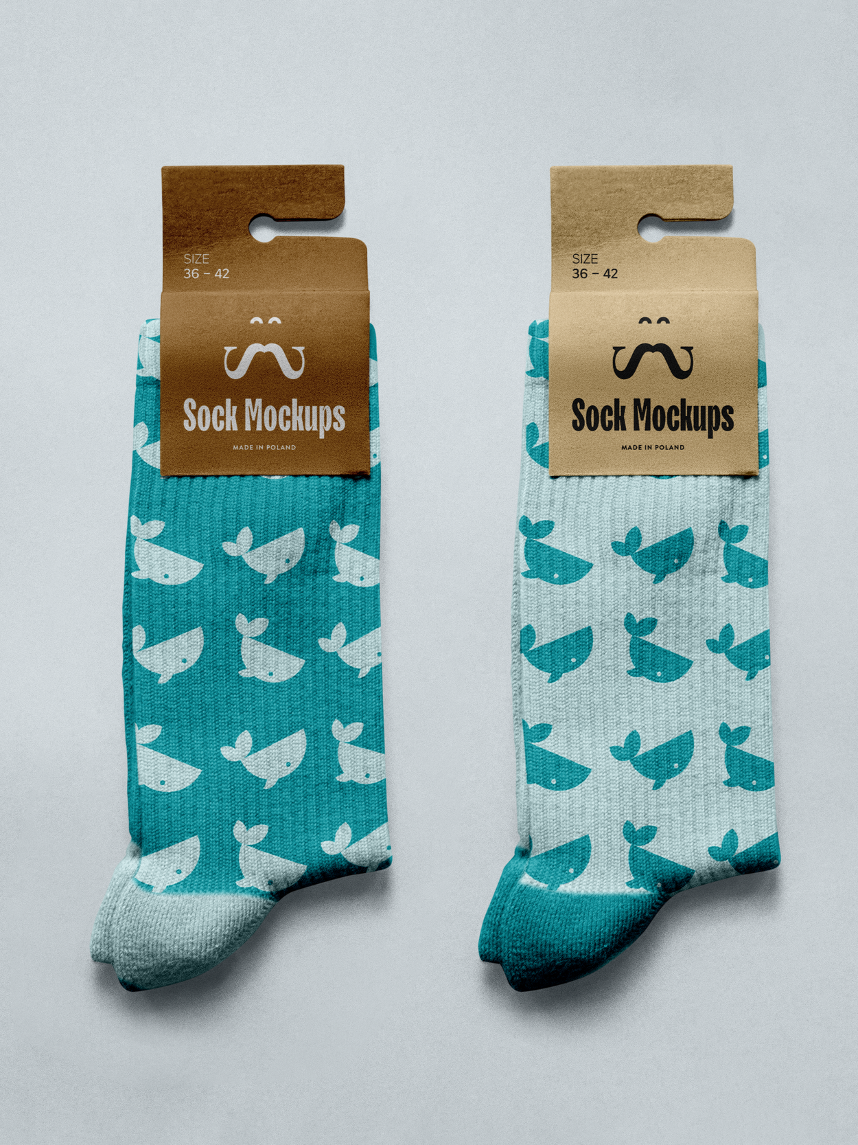 Two pairs of cartoon whale patterned socks with tag labels reading 'Sock Mockups' and 'Size 36-42', made in Poland, the left pair is blue with white whales, and the right pair is light blue with darker blue whales.