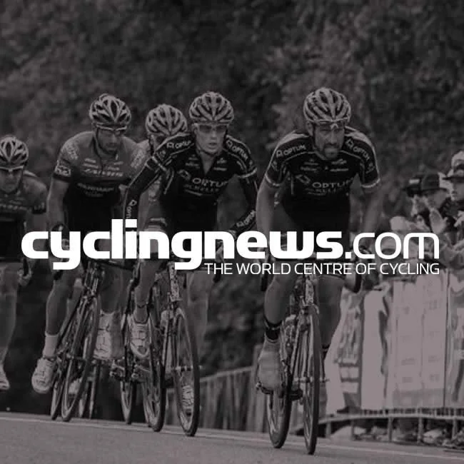 Four male cyclists in helmets and cycling gear riding on a road during a race, with spectators in the background, overlaid with the text "cyclingnews.com THE WORLD CENTRE OF CYCLING".