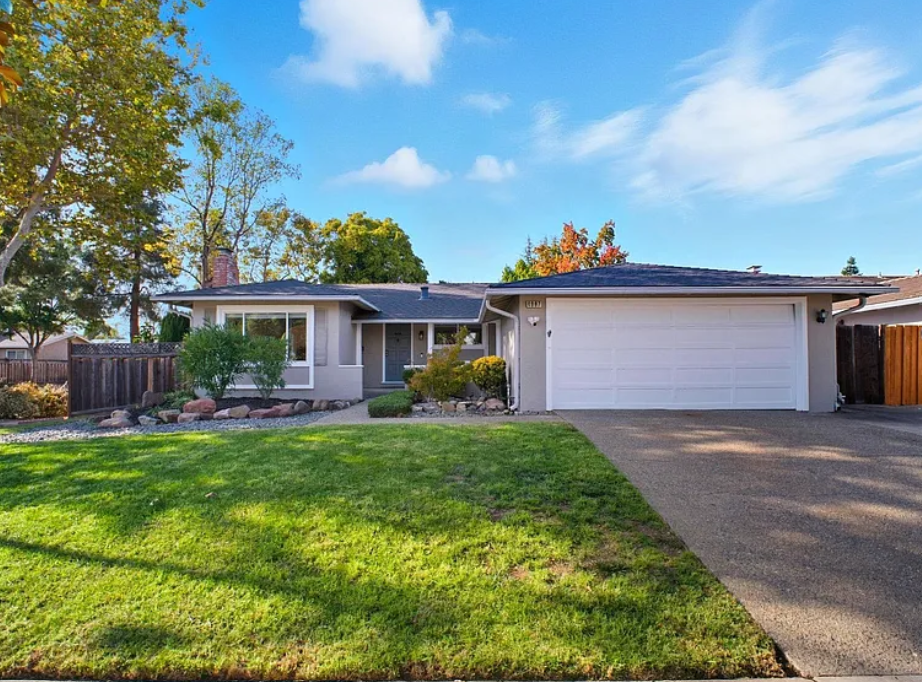 Front exterior of 4987 Winchester Place in Newark, CA featuring a single-story home with a two-car garage, manicured front lawn, mature trees, and a clean driveway leading to a modern entryway.